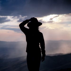 Preview wallpaper silhouette, hat, mountains, dark