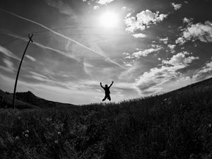 Preview wallpaper silhouette, jump, bw, field, freedom, sky