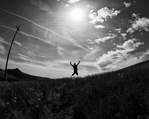 Preview wallpaper silhouette, jump, bw, field, freedom, sky