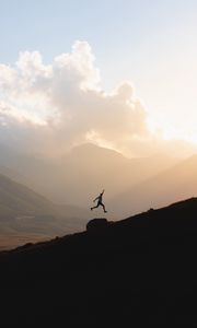 Preview wallpaper silhouette, jump, mountains, light, dark