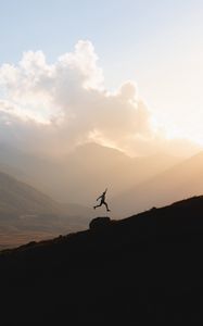 Preview wallpaper silhouette, jump, mountains, light, dark