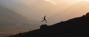 Preview wallpaper silhouette, jump, mountains, light, dark