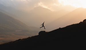 Preview wallpaper silhouette, jump, mountains, light, dark