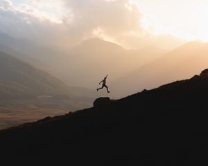 Preview wallpaper silhouette, jump, mountains, light, dark