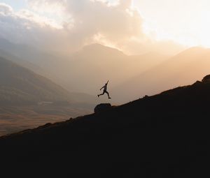 Preview wallpaper silhouette, jump, mountains, light, dark