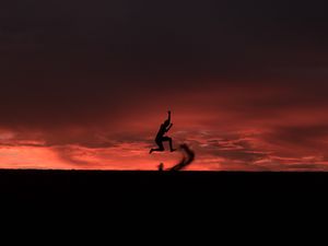 Preview wallpaper silhouette, jump, sunset, night