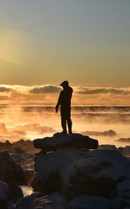 Preview wallpaper silhouette, loneliness, rocks, stones, fog, clouds, sunset