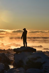 Preview wallpaper silhouette, loneliness, rocks, stones, fog, clouds, sunset