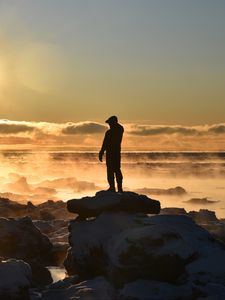 Preview wallpaper silhouette, loneliness, rocks, stones, fog, clouds, sunset