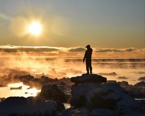 Preview wallpaper silhouette, loneliness, rocks, stones, fog, clouds, sunset