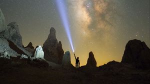 Preview wallpaper silhouette, man, lantern, glow, starry sky, rocks