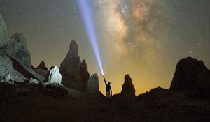 Preview wallpaper silhouette, man, lantern, glow, starry sky, rocks