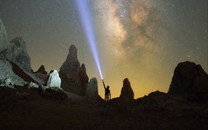 Preview wallpaper silhouette, man, lantern, glow, starry sky, rocks