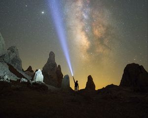 Preview wallpaper silhouette, man, lantern, glow, starry sky, rocks
