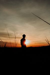 Preview wallpaper silhouette, man, light, sunset, sky, grass