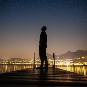 Preview wallpaper silhouette, man, night city, stars, starry sky