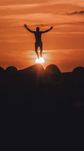 Preview wallpaper silhouette, mountains, jump, sunset