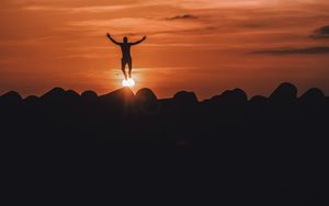 Preview wallpaper silhouette, mountains, jump, sunset