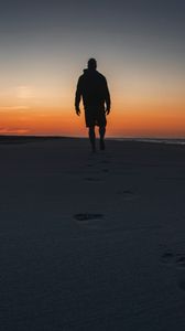 Preview wallpaper silhouette, sand, footprints, beach, sea, sunset, twilight
