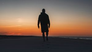 Preview wallpaper silhouette, sand, footprints, beach, sea, sunset, twilight