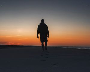 Preview wallpaper silhouette, sand, footprints, beach, sea, sunset, twilight