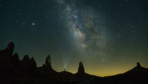 Preview wallpaper silhouette, starry sky, night, flashlight, rocks