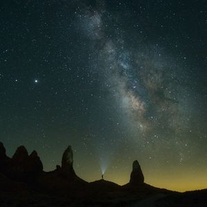 Preview wallpaper silhouette, starry sky, night, flashlight, rocks