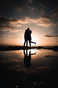 Preview wallpaper silhouettes, couple, hugs, kiss, sunset, dark