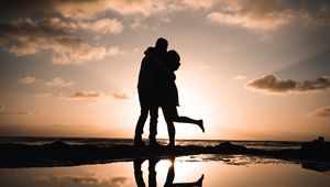 Preview wallpaper silhouettes, couple, hugs, kiss, sunset, dark