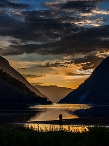 Preview wallpaper silhouettes, couple, mountains, lake, sunset, clouds, norway