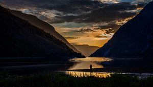 Preview wallpaper silhouettes, couple, mountains, lake, sunset, clouds, norway