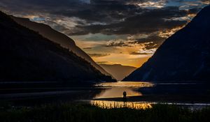 Preview wallpaper silhouettes, couple, mountains, lake, sunset, clouds, norway