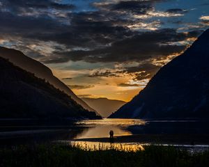 Preview wallpaper silhouettes, couple, mountains, lake, sunset, clouds, norway