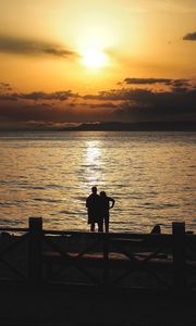 Preview wallpaper silhouettes, sunset, couple, sea, horizon