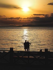 Preview wallpaper silhouettes, sunset, couple, sea, horizon