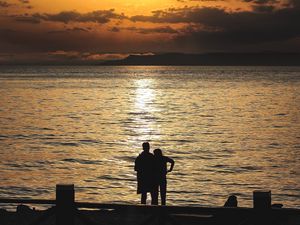 Preview wallpaper silhouettes, sunset, couple, sea, horizon