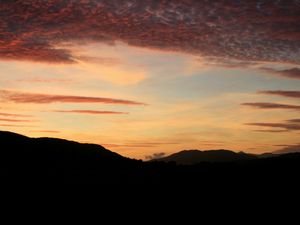 Preview wallpaper sky, clouds, sunset, hills, dark