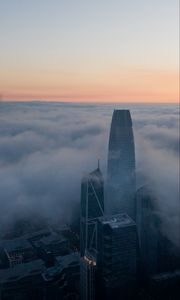 Preview wallpaper skyscraper, building, clouds, fog, city