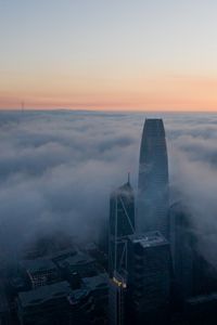 Preview wallpaper skyscraper, building, clouds, fog, city