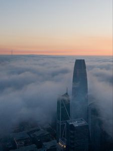Preview wallpaper skyscraper, building, clouds, fog, city