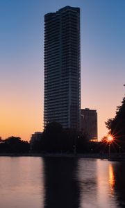 Preview wallpaper skyscraper, building, pond, sunset, city