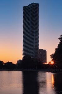 Preview wallpaper skyscraper, building, pond, sunset, city