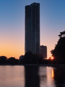 Preview wallpaper skyscraper, building, pond, sunset, city