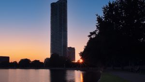 Preview wallpaper skyscraper, building, pond, sunset, city
