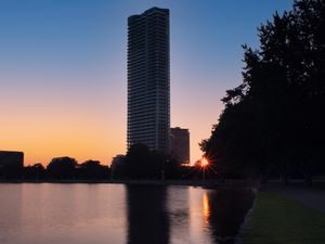 Preview wallpaper skyscraper, building, pond, sunset, city