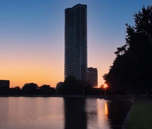 Preview wallpaper skyscraper, building, pond, sunset, city
