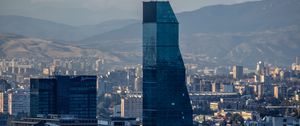 Preview wallpaper skyscraper, buildings, mountains, city