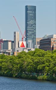 Preview wallpaper skyscraper, construction, trees, city