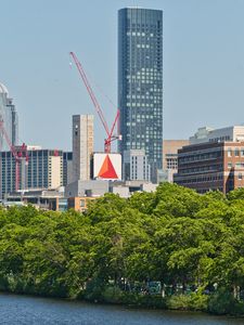 Preview wallpaper skyscraper, construction, trees, city