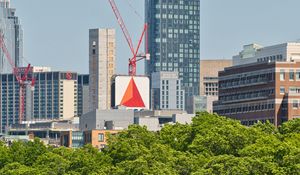 Preview wallpaper skyscraper, construction, trees, city